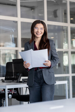 Young woman holding documents in hands and looking contented