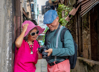 Fototapeta premium Two people check camera settings in an alley during the day in an urban area