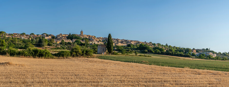Puimoisson, France - 07 04 2026: Panoramic view of Puimoisson hilltop village under a blue sunny sky