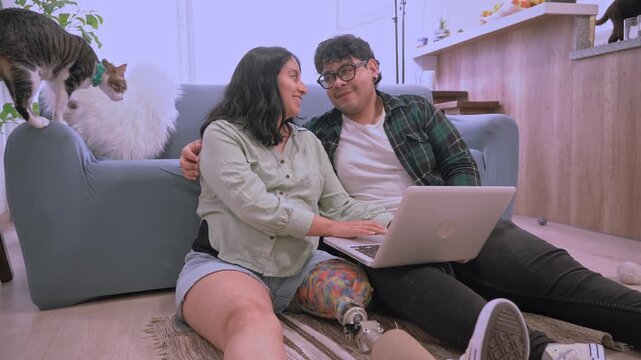 Amputee woman and her boyfriend browsing laptop at home