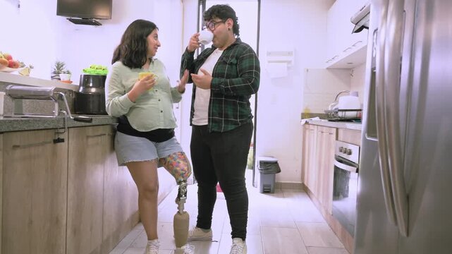 Pregnant woman with prosthetic leg and partner in kitchen