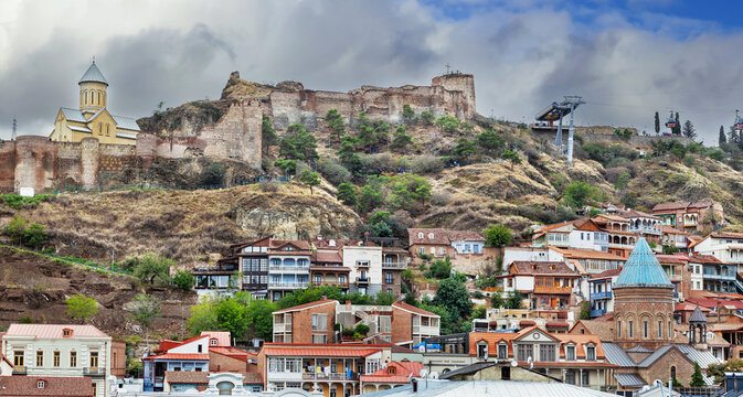 View of Narikala fortress, and Tbilisi old town, Georgia, panoramic cityscape. Overcast weather with cloudy sky