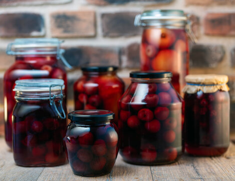 Cherry compote with a striking, vibrant color. Rustic-s compote with a striking, vibrant color. Rustic-style glass jars. Homemade food. Compote with a striking, vibrant color. Rustic-style glass jars.