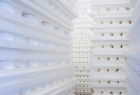 Stacks of white polystyrene insulation sheets forming an abstract industrial background texture