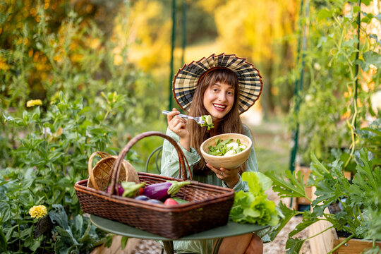 Woman Enjoying Fresh Garden Salad in Organic Vegetable Garden
