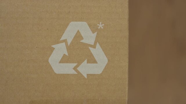 Recycling sign printed brown cardboard packaging background. White symbol emphasizing sustainable materials eco friendly shipping solutions commercial green marketing campaigns macro detail paper box 