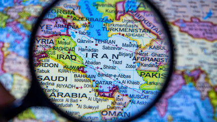 Close up of magnifying glass highlighting Iran and surrounding Middle Eastern countries. © Photo Agency