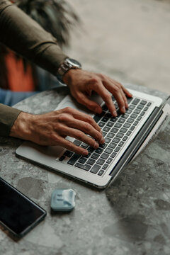 Person hands typing on laptop keyboard working remotely