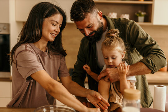 Happy family baking together in kitchen, preparing food