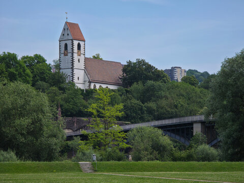 germany, historic st blasius church and graceful bridge framed by vibrant green trees beneath deep blue summer sky in plochingen