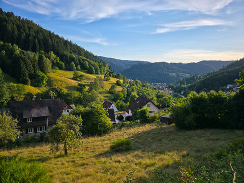 germany, panoramic sunset overlooking schramberg village nestled in the schwarzwald valley beneath deep blue summer sky with charming traditional houses and vibrant nature