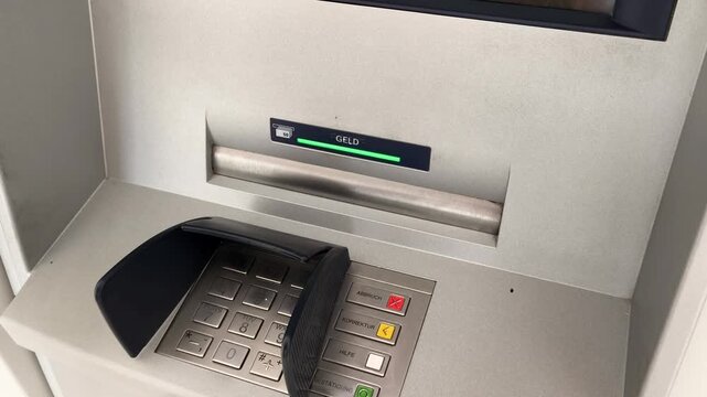 Close-up of a man's hand withdrawing a fifty euro banknote from an ATM cash machine
