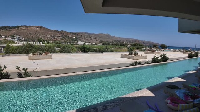 Beautiful view of timelapse over five star resort pool with mountains and Cretan Sea beyond. Greece. Crete.