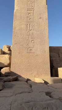 View from bottom to top detailed view of the Obelisk of Thutmose I at Karnak Temple, Luxor, Egypt. Features deep-carved hieroglyphs on sunlit granite, representing the grandeur of ancient civilization