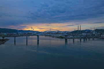 Fototapeta premium Aerial drone photo of Shunan Ohashi bridge and industrial zone at sunrise, Yamaguchi, Japan