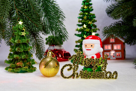 Santa Claus with letters and a yellow ball against a background of Christmas trees with a house and a car