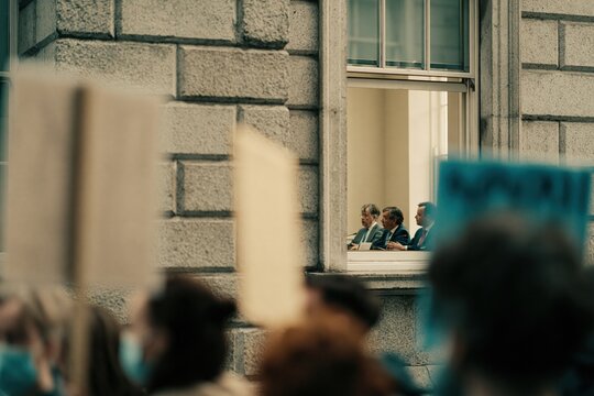 Civilian protesters gather outside government building while lawmakers meet inside