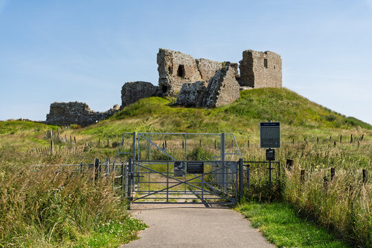 Duffus Castle ruins standing prominently on a grassy hill under a clear July sky in Moray, Scotland