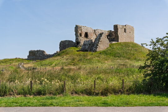 Duffus Castle ruins standing on a green mound under a clear blue sky in July, Moray, Scotland