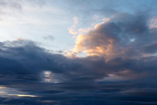 Evening sky with dramatic clouds lit by fading sun