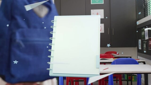 Students walking behind animated spiral notebook appearing, floating in classroom with backpacks
