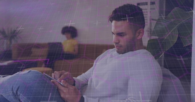 Man tapping tablet in home, initiating purple grid aligning with taps while navigating tech app