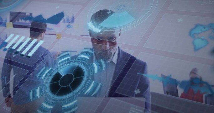 Man in suit typing on laptop in tech office, initiating holographic HUD overlaying charts for team