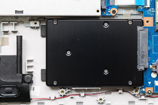 Internal SSD in notebook. Close-up of the solid state drive storage device connected via SATA interface to circuit board Maintenance and repair of a consumer computer.