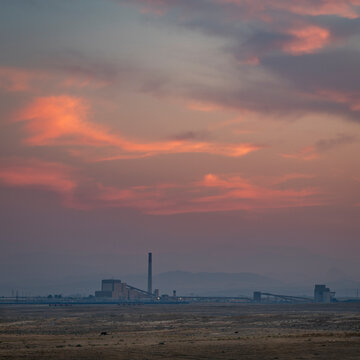 dusk over prairie and foothills of northern Colorado near Fort Collins with a distant power plant, late summer scenery with haze and smoke from wildfires