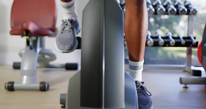 Man starting workout, performing alternating stepping on stepper at gym wearing grey shoes