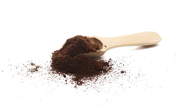 Milled coffee powder in wooden spoon isolated on white background, side view