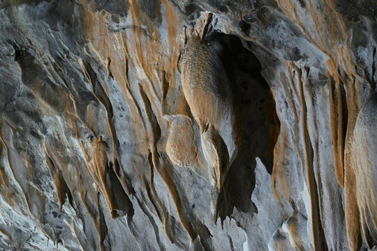 Vibrant orange cave draperies and mineral rock formations on the wall inside Kovacevica cave Serbia
