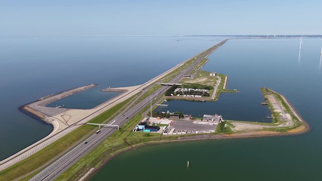 Aerial view of afsluitdijk causeway with car traffic and wind turbines