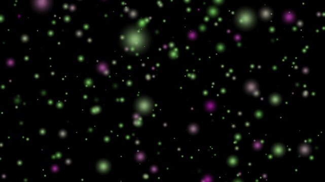 Floating green and purple glowing particles on a black background, ethereal abstract motion Video