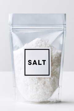 Clear resealable plastic bag filled with white salt, featuring a bold black label displaying the word SALT against a minimalistic background