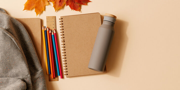 Back to school flat lay featuring a notebook pencils ruler water bottle and autumn leaves