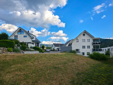 germany, beautiful newly built houses in sonnensiedlung elzach surrounded by peaceful black forest scenery beneath glowing colorful summer sunset sky