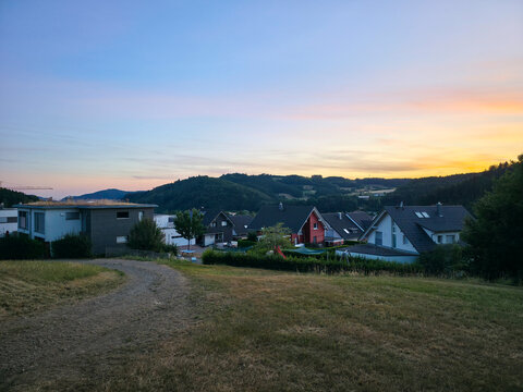 germany, glowing sunset above elzach village revealing picturesque rooftops and peaceful schwarzwald scenery under brilliant deep blue summer evening sky