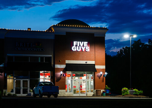 New Hartford, Jul 3, 2026: Low-Key night view of Five Guys restaurant, an American fast‑casual burger & fries retailer with over 1,800 locations worldwide, part of Five Guys Holdings Inc.