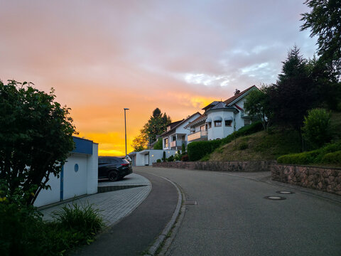 germany, beautiful winding road through elzach black forest village beneath radiant orange sunset creating unforgettable summer countryside landscape experience