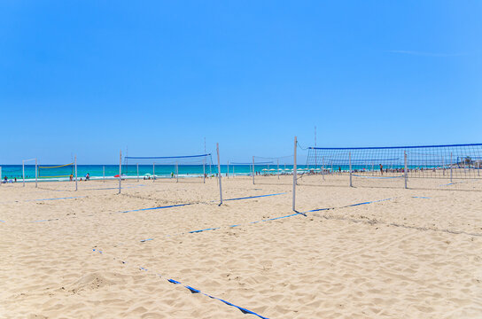 Playa de San Juan beach in Alicante city, sports area volleyball courts with volleyball net on sandy beach of Mediterranean Sea coast Costa Blanca in sunny summer day, Valencian Community, Spain