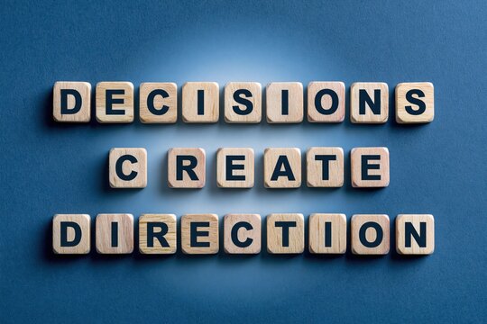 Decisions create direction phrase written with wooden tiles on blue background