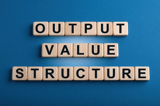 Output value structure phrase made of wooden letter tiles on blue background