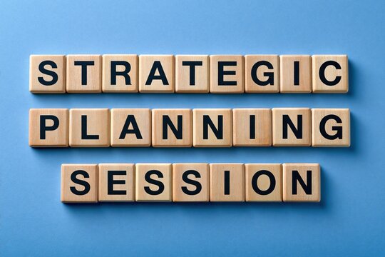 Strategic planning session phrase written with wooden tiles on blue background