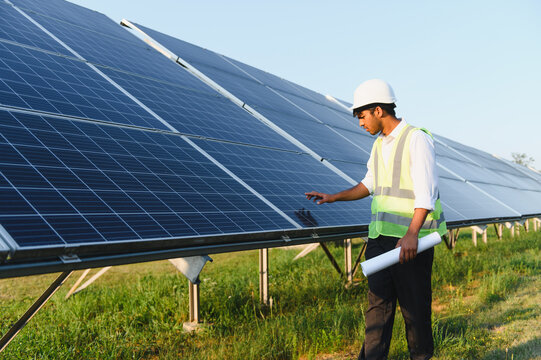 Indian engineer inspecting solar panels at power farm