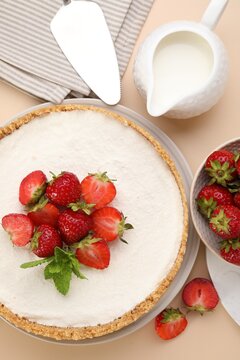 Yummy cheesecake with strawberries and milk on beige table, flat lay