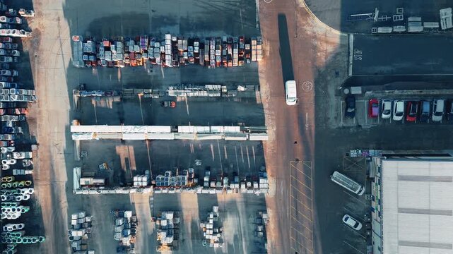 Vehicles line rows across asphalt. Industrial chemical plant