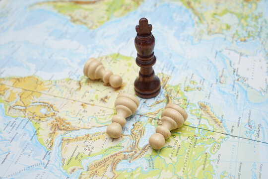 Black king chess piece standing on a map while white bishops lie fallen, symbolizing strategy, conquest, geopolitical conflict, tactical dominance and global power shifts