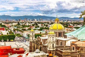 Basilica of Saint Mary of Guadalupe and Mexico City skyline. The church is located at the foot of the Hill of Tepeyac in the Gustavo A. Madero borough of Mexico City. © mandritoiu