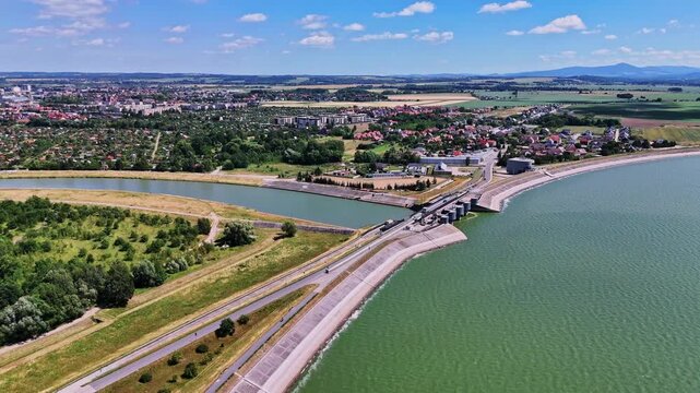 Drone flight over Nysa Lake dam with city skyline and river view, Poland
